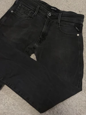 Replay anbass - Säljer ett par svarta jeans från Replay med smal passform och klassisk femficksdesign. Jeansen har diskreta snygg slitningar men dem kommer ifrån fabrik så inget är skapat av användning, väldigt fint skick eftersom jag har använt dem för att dem ska hålla och behålla den fina naturliga looken. Materialet är mjukt och stretchigt för extra komfort. W31 L32