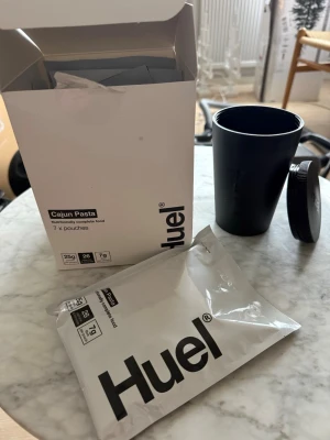 Huel Cajun Pasta måltidspaket + shaker - Säljer ett Huel Cajun Pasta måltidspaket med 6 portionspåsar och en svart shaker med lock. Perfekt för dig som vill ha ett snabbt och näringsrikt mål. Allt är i originalförpackning och enkelt att ta med. Bäst före mars 2026
