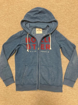 Blå zip-hoodie från Hollister - Hollister hoodie i mycket bra skick! Tröjan är använd men har inga defekter, storlek M, Hör av er om frågor!