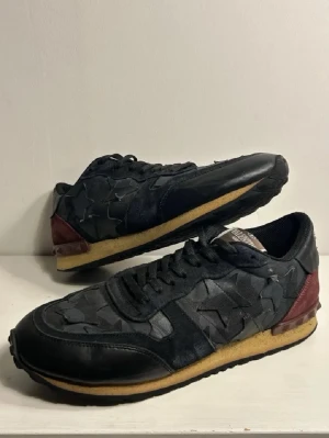Valentino Rockrunners  - Snygga sneakers från Valentino med stjärndetaljer och vinröda inslag. Skorna har en unik design med stjärnor på sidorna och nitar på hälen. Perfekta för vintern. Skriv vid ytterligare frågor eller funderingar🤝 strl 42.                                  Kan gå ner i pris vid snabb affär⭐️⭐️