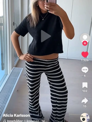 Svarta och vita mönstrade byxor - Säljer ett par trendiga svarta byxor med vågigt vitt mönster. Midjan är elastisk. Säljer då de tyvärr är för små för mig nu men annars är det inga fel på byxorna💗