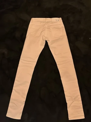 Tiger of Sweden jeans - Snygga vita skinny jeans från Tiger of Sweden med klassisk femficksdesign och låg midja. Jeansen har smal passform och är tillverkade i ett stretchigt bomullsmaterial för extra komfort. Perfekta för en stilren och modern look.