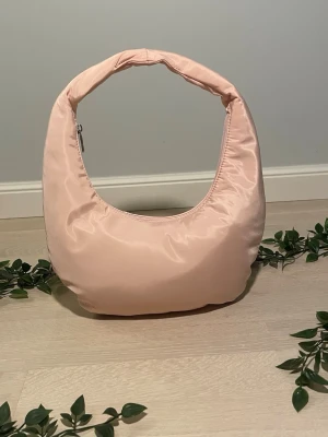 ✨ HVISK Amble Nylon Recycled Small – Ljusrosa - Säljer min superfina HVISK-väska i modellen Amble Nylon Recycled Small i en lyxig ljusrosa/babypink färg! 🌸 Väskan är från det danska designmärket HVISK och är gjord i 100% återvunnet material – snyggt OCH hållbart! Modell: HVISK Amble Nylon Recycled Small Färg: Light Pink / Babyrosa Material: 50% återvunnen nylon, 50% återvunnet polyester – vegansk! Mått: 📐 Bredd: ~30 cm 📐 Höjd: ~18 cm 📐 Djup: ~6 cm 📐 Total höjd med handtag: ~36 cm Stängning: Dragkedja Fickor: Innerficka med dragkedja Handtag: 