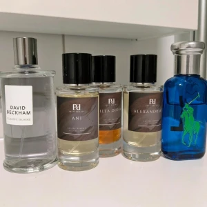 Parfymset med fem olika dofter - Säljer ett parfymset med fem flaskor: en klassisk David Beckham-flaska i silver och glas, tre Pd flaskor med svarta lock och etiketter (Ani, Vanilla Diorama, Alexandria), samt en blå Ralph Lauren-flaska med grön logga och silverlock. Perfekt för dig som gillar att variera doft.