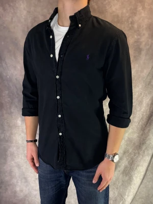 Svart Ralph Lauren Skjorta - Stl M, Slim fit - RIKTIGT FET RL SKJORTA I FÄRGEN SVART MED LILLA PONY! 👔Mycket bra skick: 9,5/10, utan defekter! | Stl: M, Modellen är 175cm och väger ca 77kg,  | Hör av dig vid frågor // Galgen 🫡