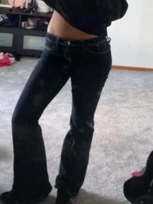 Mörkblå bootcut jeans - Snygga mörkblå bootcut jeans med låg midja och klassisk femficksdesign. Jeansen har utsvängda ben och är perfekta för en trendig och avslappnad look. Passar dig som gillar en retrostil och vill ha ett par jeans som sticker ut.