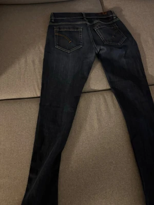 Dondup george - Säljer ett par mörkblå slim fit jeans med snygga kontrastsömmar och klassiska fem fickor. Jeansen har en lätt tvättad look och raka ben. Perfekta för dig som gillar en enkel men stilren stil. Köpte precis men dem var för små tyvärr