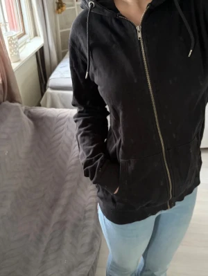 Svart zip hoodie med fickor - Säljer en svart zip hoodie från lager157 i storlek M. Inte använd så mycket, så den är i fint skick. Hör av dig om du har någon fråga!