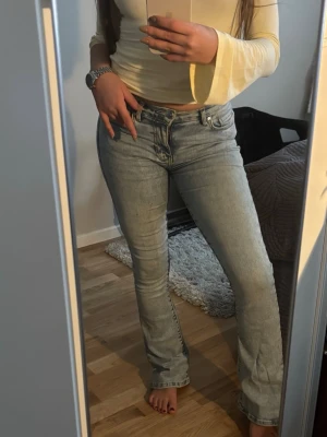Ljusblå bootcut jeans  - Säljer ett par ljusblå bootcut jeans från Bikbok med klassisk femficksdesign. Jeansen har en snygg tvättad look och är tillverkade i denim med stretch för skön passform. Perfekta till en avslappnad stil.