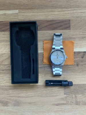 Herrklocka Kvartz 41mm Poedagar - Stilren klocka från Pagani Design i silverfärgat rostfritt stål. Klockan har en klassisk rund urtavla med datumvisning och tydliga markeringar. Länken är robust och ger en modern känsla. Perfekt accessoar för dig som gillar en clean look.