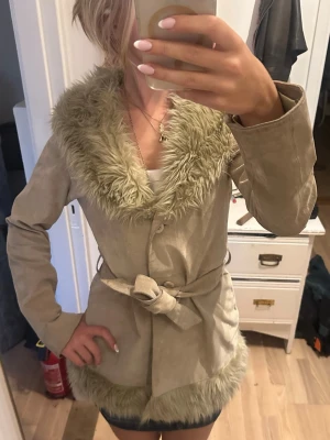 päls kappa - Snygg beige kappa med pälsdetaljer🩷Kappan är knytband i midjan för en markerad siluett, perfekt för dig som vill ha en trendig och mysig look under kyliga dagar!