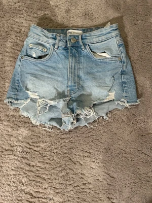 Ljusblåa denimshorts med fransig kant