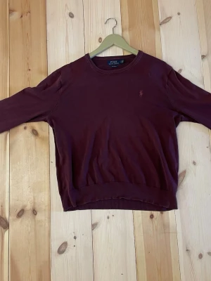RL stickad tröja - Stickad Ralph lauren sweatshirt som är vinröd. Storlek M men passar small väldigt bra.             försöker skicka så fort jag kan!