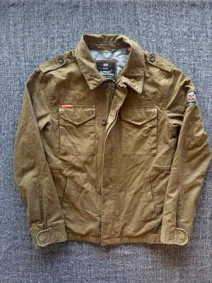Superdry field jacket ~ vintage  - Säljer nu denna sjukt snygga Superdry jackan | st M ~ 175–185cm | olivgrön/brun färg som passar perfekt till hösten! Modellen produceras inte längre och är därav väldigt sällsynt. Kan även gå ner lite i pris vid snabb affär🍁🫶
