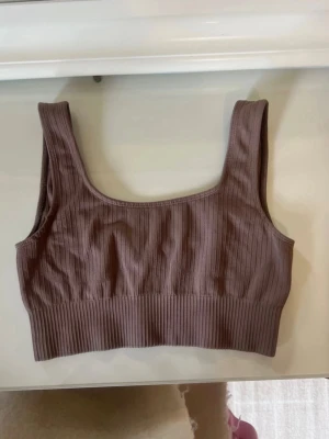 Brunt träningsset, tights och topp - Träningsset i brunt i storlek S. Setet består av ett träningslinne och matchande tights. 