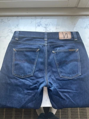 Nudie Selvage Jeans - Nudie Gritty Jackson Jeans Model: Gritty Jackson Färg: Mörkblå Storlek: w30 l32 Skick: 9/10 Material: Dry Maze Selvage Modellen är 179cm lång och 65kg