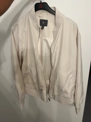 Snygg Beige Bomberjacka H&M - Strl L - Säljer en snygg och fräsch beige bomberjacka från H&M i storlek L. Jackan är i fint skick och har en klassisk design med muddar i midja och ärmslut. Perfekt som vår- eller höstjacka! ✨ Kika gärna på mina andra varor på sidan! Jag säljer just nu av en stor del av garderoben med allt från märkeskläder och rejäla jackor till snygga basplagg. 🎁 Mängdrabatt: Jag erbjuder bundle-rabatter om du köper flera saker samtidigt – spara både på priset och frakten! Skickas spårbart och säkert. Har du några frå