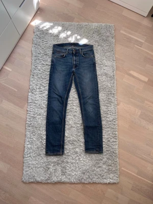Blå Nudie Jeans Grim Tim - Nudie Jeans - Grim Tim - W29 L30 - Skicket är okej, se bild 5 (litet hål) - Feta fades - Tveka inte att skriva vid funderingar, frågor om mått etc.