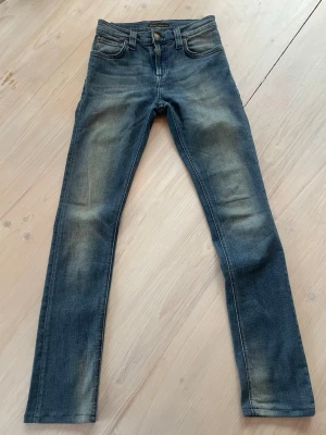 Blå slim fit jeans - Snygga blå slim fit jeans med slitna detaljer på låren och knäna. Jeansen har en tvättad look och raka ben. Perfekta för en avslappnad och trendig stil. Storlek W27 L32