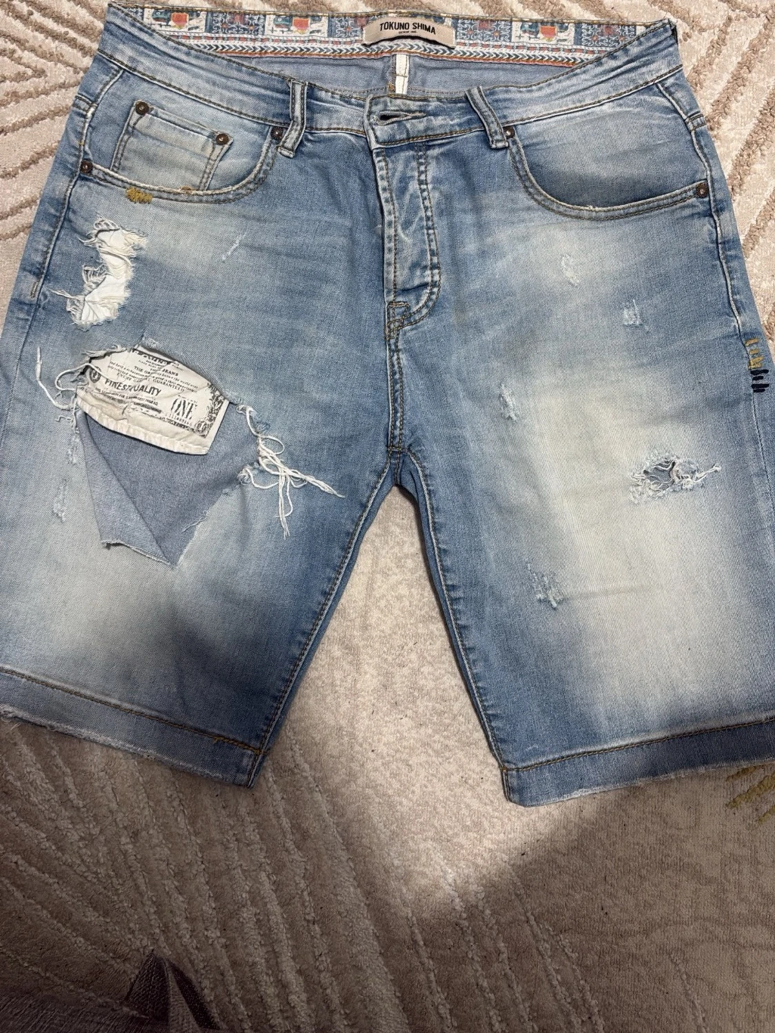 Ljusblå slitna jeansshorts