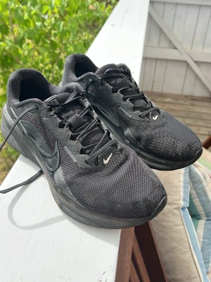 Svarta Nike sneakers med mesh - Snygga svarta Nike sneakers. Skorna har klassisk snörning, diskret swoosh-logga på sidan och slitstark gummisula med bra grepp. Perfekta för dig som gillar sportig och lätt att hoppa runt i. Samtidigt en clean stil. Dem är använda men i bra skick. Storlek 43 men passar 42 också.