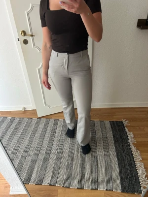 Ljusgrå kostymbyxor med raka ben - Säljer ett par ljusgrå kostymbyxor med raka ben och medel midja. Storlek 34 Petit modellen 