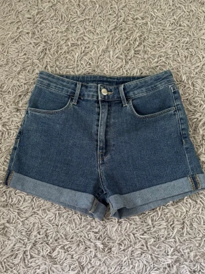 Blå denimshorts  - Blue mid waist denimshorts in size 34