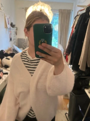 Ljusrosa fluffig kofta - Mysig ljusrosa kofta med fluffig känsla och avslappnad passform. Koftan har långa ärmar och en öppen front, perfekt att slänga över en t-shirt eller topp. Passar dig som gillar en soft och chill stil.