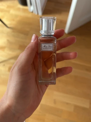 Miss Dior Blooming Bouquet parfym - Elegant parfymflaska från Dior, Miss Dior Blooming Bouquet. Flaskan är rektangulär i genomskinligt glas med dekorativ struktur och silverfärgat lock. Innehållet är ljusrosa. Perfekt för dig som gillar fräscha och blommiga dofter. Köptes för 569 kr. Använd fåtal gånger. Är 20 ml men gick inte att ställa in det, det är en roll on