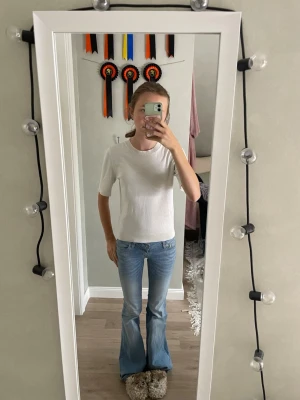 Vit enkel t-shirt med kort ärm - Klassisk vit t-shirt med rund hals och korta ärmar. Modellen är rak och har en normal passform. Perfekt basplagg som funkar till allt och är lätt att styla med olika outfits.