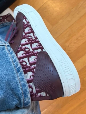 Intressekoll vinröda walk in dior sneakers  - Hejsan! Intressekoll på mina vinröda dior skor köpa på vestaire collective! Dom är i super bra skick. Dom är lite mer använda än på bilderna har haft dom i typ en månad. Men använder väldigt lite! Jag vill se intresset på dessa skor. Dom är i storlek 41 jag brukar ha 40 och dom passar mig men allas fötter är olika. Om dom är för stora så kan man säkert stoppa in sula osv. Dom säljs inte längre därför högre pris & eftertraktade!! Skriv vid frågor eller funderingar :)