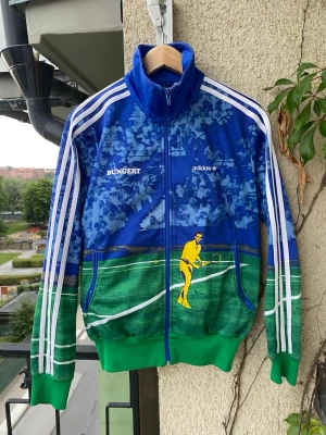 Vintage Adidas Originals ”Bungert” Träningsjacka - Vintage Adidas Originals ”Bungert” Träningsjacka Unik och sällsynt vintage träningsjacka från Adidas Originals. Jackan är en hyllning till den tyske tennislegendaren Wilhelm Bungert. Storlek S herr.