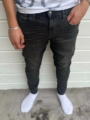 Levis jeans mörkgrå slim - Hej! Säljer dessa snygga mörkgrå levis jeans i gott skick. Inga defekter förekommer! Modellen på bilden är 183cm och väger 68kg. Passformen är slim och storleken är W30/L31. Hör av dig vid minsta intresse! Mvh DC ♦️