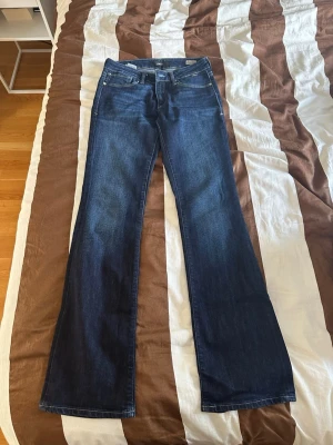 Mörkblå bootcut jeans - Snygga mörkblå jeans med bootcut passform och klassisk femficksdesign. Jeansen har normal midja och kontrastsömmar. Tillverkade i ett mjukt denimtyg som ger en skön känsla och sitter snyggt på benen. Märke Mavi storlek 27/34