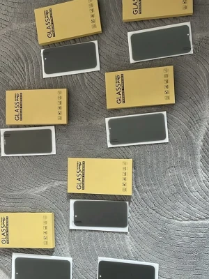 GLASS PRO skärmskydd till iPhone - Säljer flera GLASS PRO skärmskydd till iPhone. Skydden är genomskinliga och tillverkade i härdat glas, perfekta för att hålla skärmen fri från repor och stötar. Kommer i gul förpackning och passar olika iPhone-modeller. Enkla att applicera och ger ett stilrent skydd.