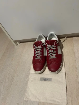 Valentino flycrews - Säljer nu ett par röda flycrews. Just nu är det ett par vita snören på men man får med original snören samt dustbag vid köp. Skorna är synligt använda. 5 st nitar har lossnat. Priset är ej hugget i sten.