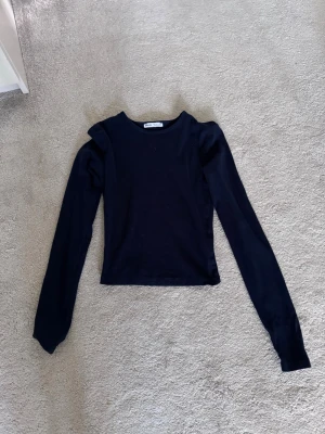 Marinblå långärmad topp  - Snygg marinblå långärmad topp med rund hals. Modellen är croppad och har en stilren look som passar till det mesta. Tillverkad i mjukt material som känns skönt mot huden. Perfekt för dig som vill ha en enkel men trendig topp.
