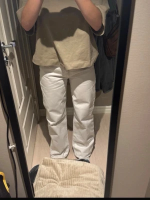 Vita raka jeans med hög midja - Säljer ett par vita jeans med rak passform och hög midja. Jeansen har klassisk femficksdesign och stängs med dragkedja och knapp. Perfekta för en clean och stilren look. Materialet ser ut att vara bomull. Några fläckar finns se bild.