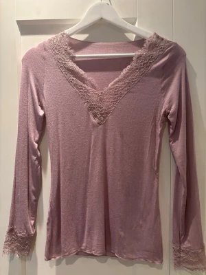 Ljusrosa Intimissimi topp med spets - Ljusrosa cashmere topp från Intimissimi med spets i urringningen och ärmarna. Använd ett par fåtal gånger och i mycket fint skick.