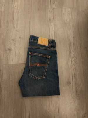 Blå smala jeans från Nudie Jeans - Ett par blå jeans från Nudie Jeans med slim passform✅. Jeansen är använda fåtal gånger och har inga defekter! Modellen på jeansen är lean Dean och är en slim passform 👖Skriv vid funderingar!