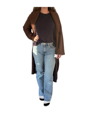 Brun ullkappa från Farhi by Nicole Farhi - Mysig brun kappa i 100% ull från Farhi by Nicole Farhi. Kappan har en avslappnad passform, sjalkrage och knytskärp i midjan. Perfekt för kyliga dagar och ger en stilren look. Storlek S (10/36). Modellen är 1.71 m lång och har S/M i storlek. Helt ny och såklart oanvänd!
