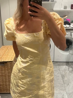 Ginatricot brocade puffsleeve mini dress GUL - Säljer denna otroliga klänning från gina i färgen gul. Har behållt en annan i samma storlek därför säljer jag denna. Klänningen är super fin med väldigt bra passform. Sömmen vid ryggen har tyvärr gått upp lite, går att sy igen och inget som syns när klänningen är på💕