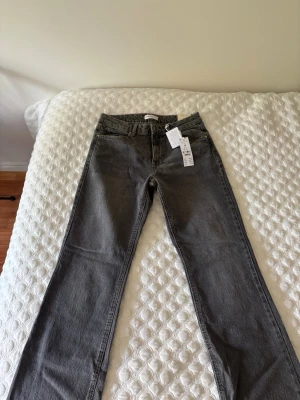Grå raka jeans  - Säljer ett par snygga grå jeans med raka ben. Jeansen har klassisk femficksdesign och bälteshällor. Materialet är kraftigt denim som ger en tidlös look. Perfekta till en avslappnad stil och passar till det mesta i garderoben. Jeansen är aldrig använda och har prislappen kvar☺️