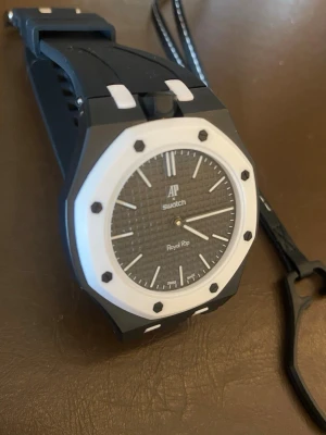  Swatch Royal Pop klockor - Säljer  Swatch Royal Pop klockor med ikonisk åttakantig form. En är svart med vit ram och detaljer, den andra är blå med orange detaljer. Båda har silikonarmband och sportig design, perfekta för dig som vill sticka ut med färg och stil. Pris kan diskuteras vid snabb affär