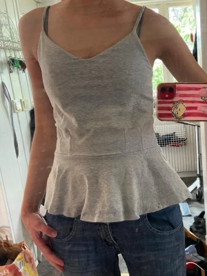 Topp  - Grå topp/linne med volang från BikBok 💕storlek: S!! Hör av dig om du har några frågor! :)