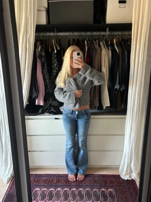 Blå bootcut jeans med låg midja - Säljer ett par ljusblå bootcut jeans med låg midja och klassiska fem fickor. Jeansen har dragkedja och knapp framtill samt bälteshällor. Använd några fåtal gånger 💕💕