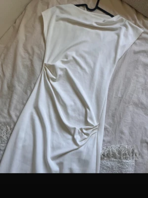 Vit lång klänning med drapering - Helt ny har en liten brun sträck vid halsen men går nog bort med en tvär ( se bild).   Pris kan diskuteras.