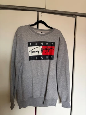 Grå sweatshirt Tommy Hilfiger - Snygg grå sweatshirt med Tommy Hilfiger tryck. 