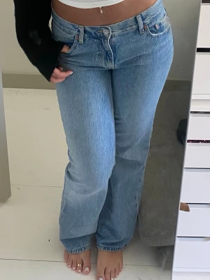 Ljusblå raka jeans med hög midja - Säljer ett par ljusblå jeans med rak passform och hög midja. Jeansen har klassisk femficksdesign, bälteshällor och knappgylf. Materialet är denim i bomull och färgen är snyggt tvättad ljusblå. Perfekta till sneakers eller boots!