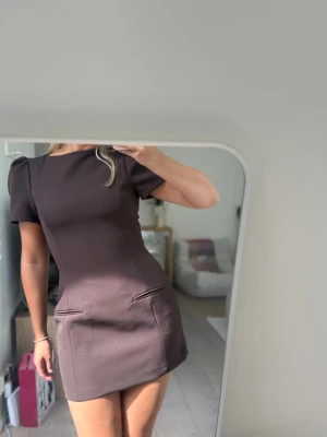 Viral Zara klänning - Säljer en brun kort klänning med puffärmar och figursydd passform. Från Zara i storlek M med prislapp på! Originalpris 499kr🤎